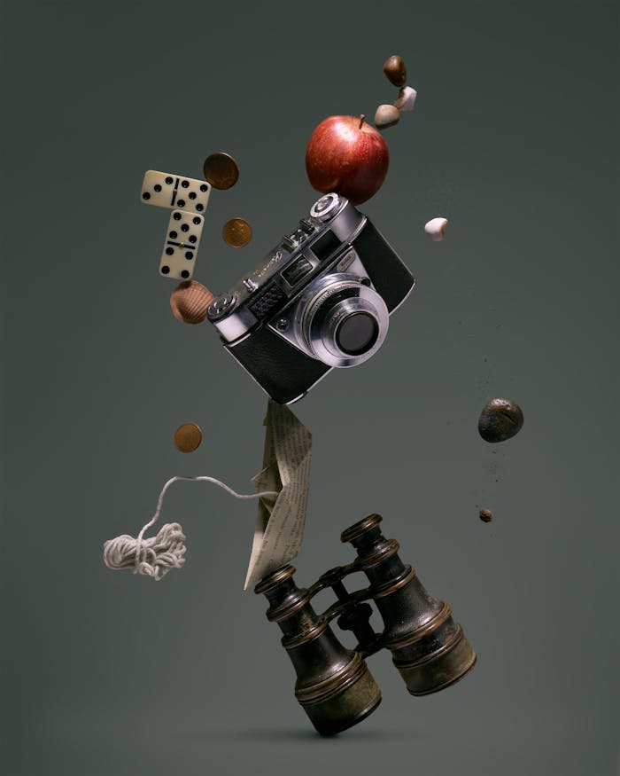 A creative arrangement of vintage items floating mid-air, including a camera, apple, and binoculars.